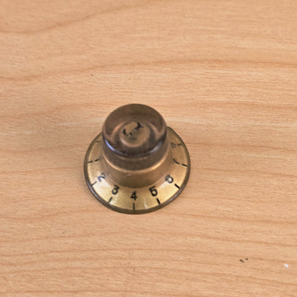 Side angle of gold top hat guitar control knob