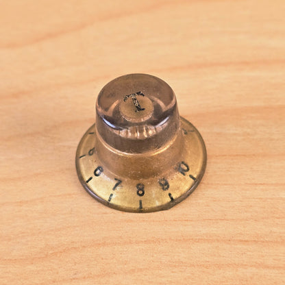 Angled view of gold top hat guitar control knob showing 0-10 numbering