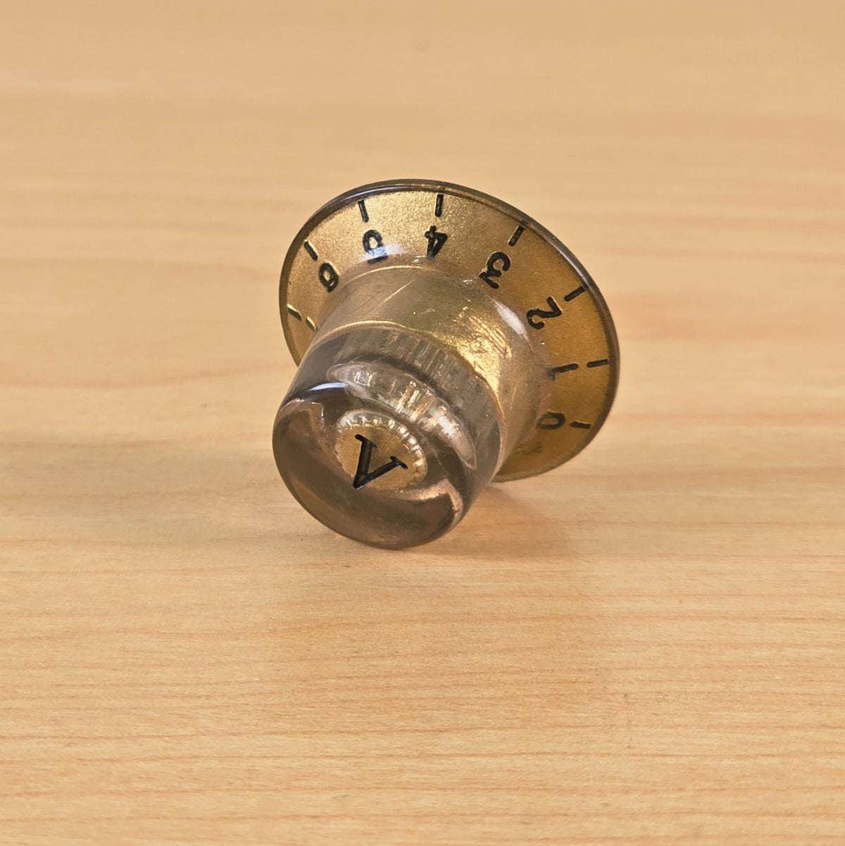 Side angle view showing profile of gold top hat control knob