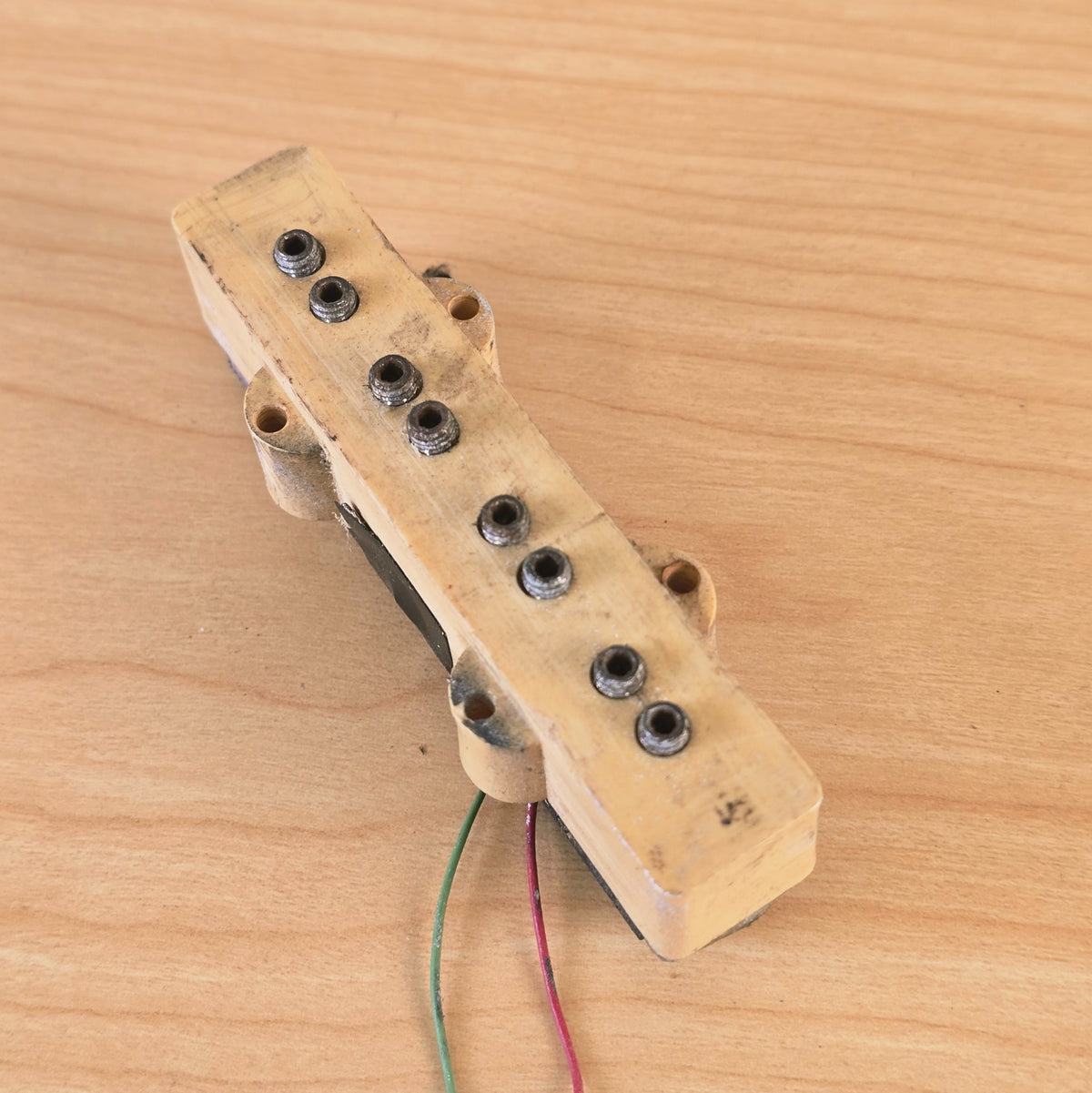 Top overhead angled view of cream 4-string bass pickup.