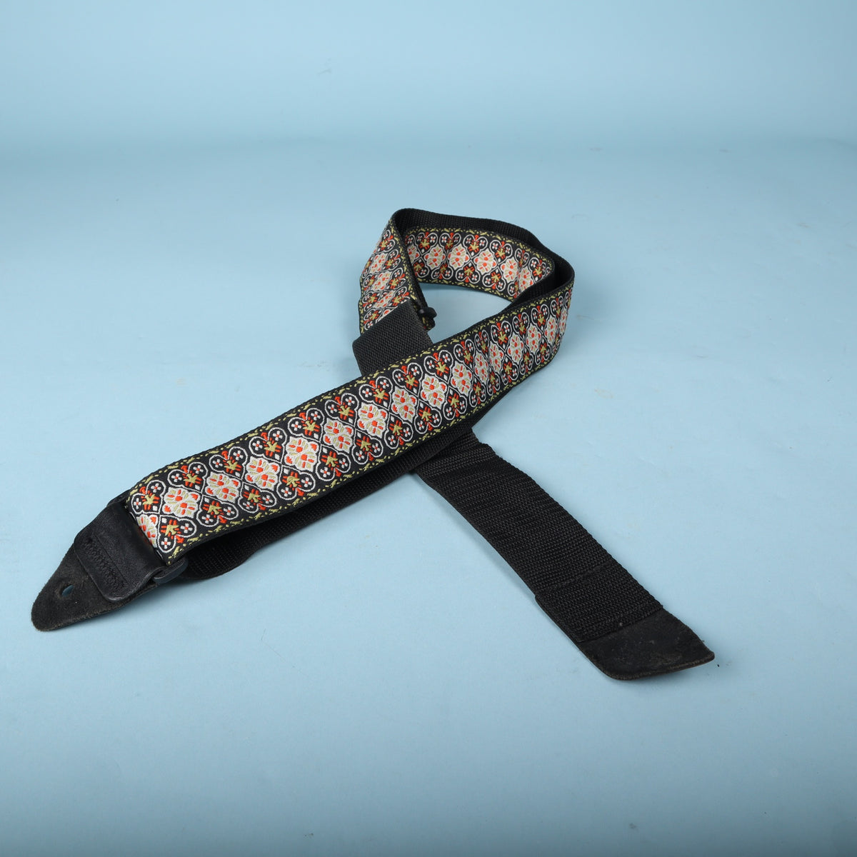 Angled view of the folded Ernie Ball woven jacquard guitar strap