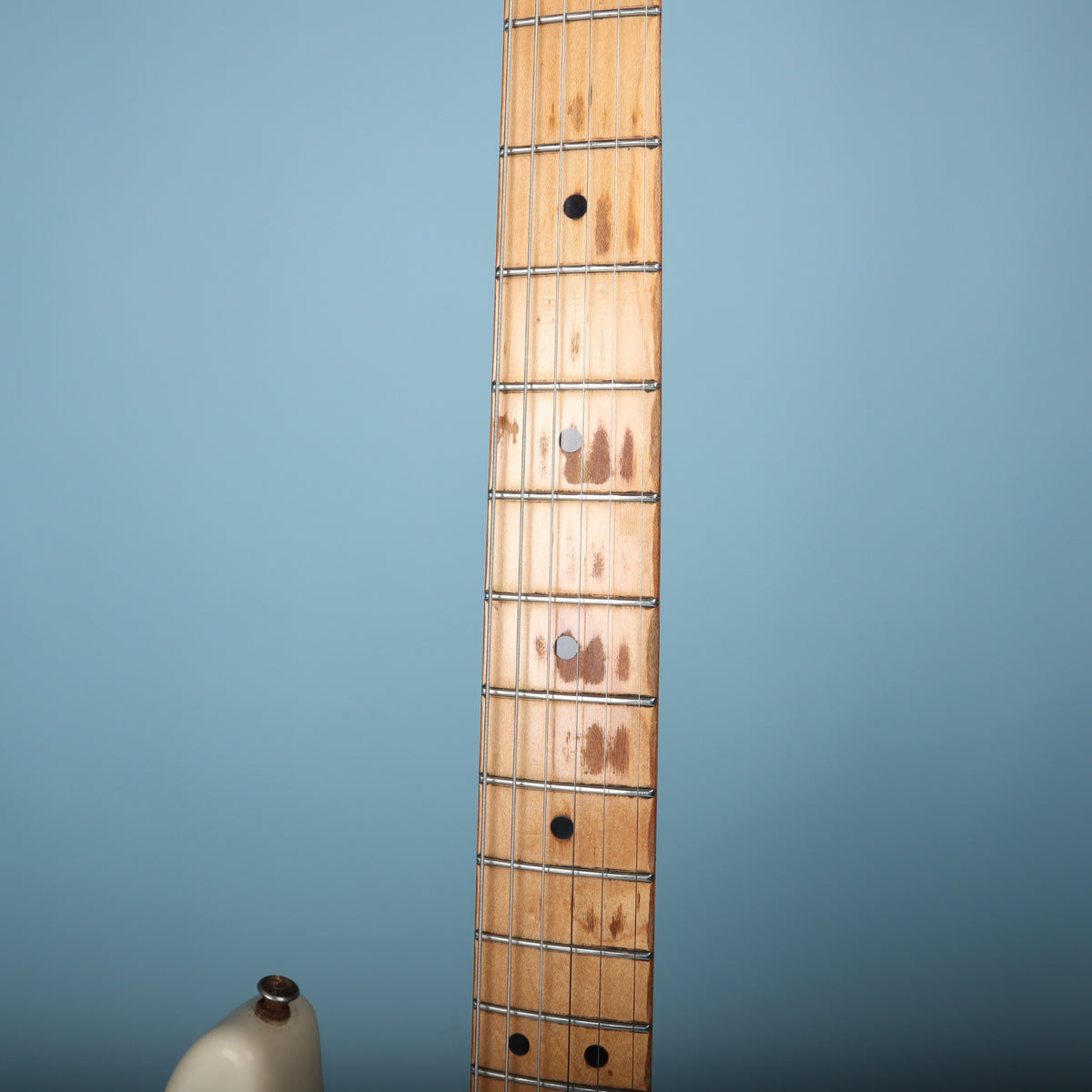 View of maple fretboard showing dot inlays and play wear patterns