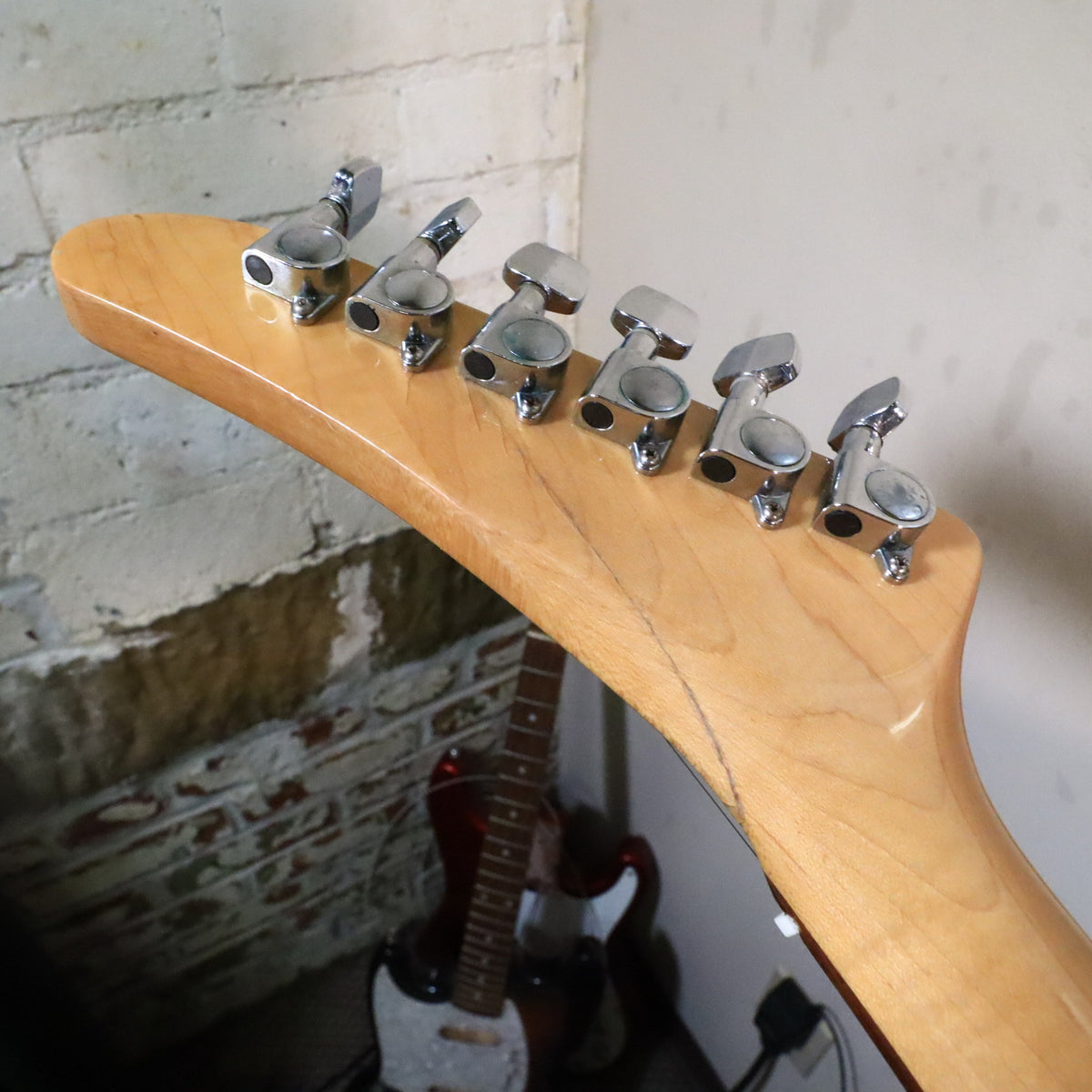 Rear headstock close-up showing repaired fracture line behind upper tuners.
