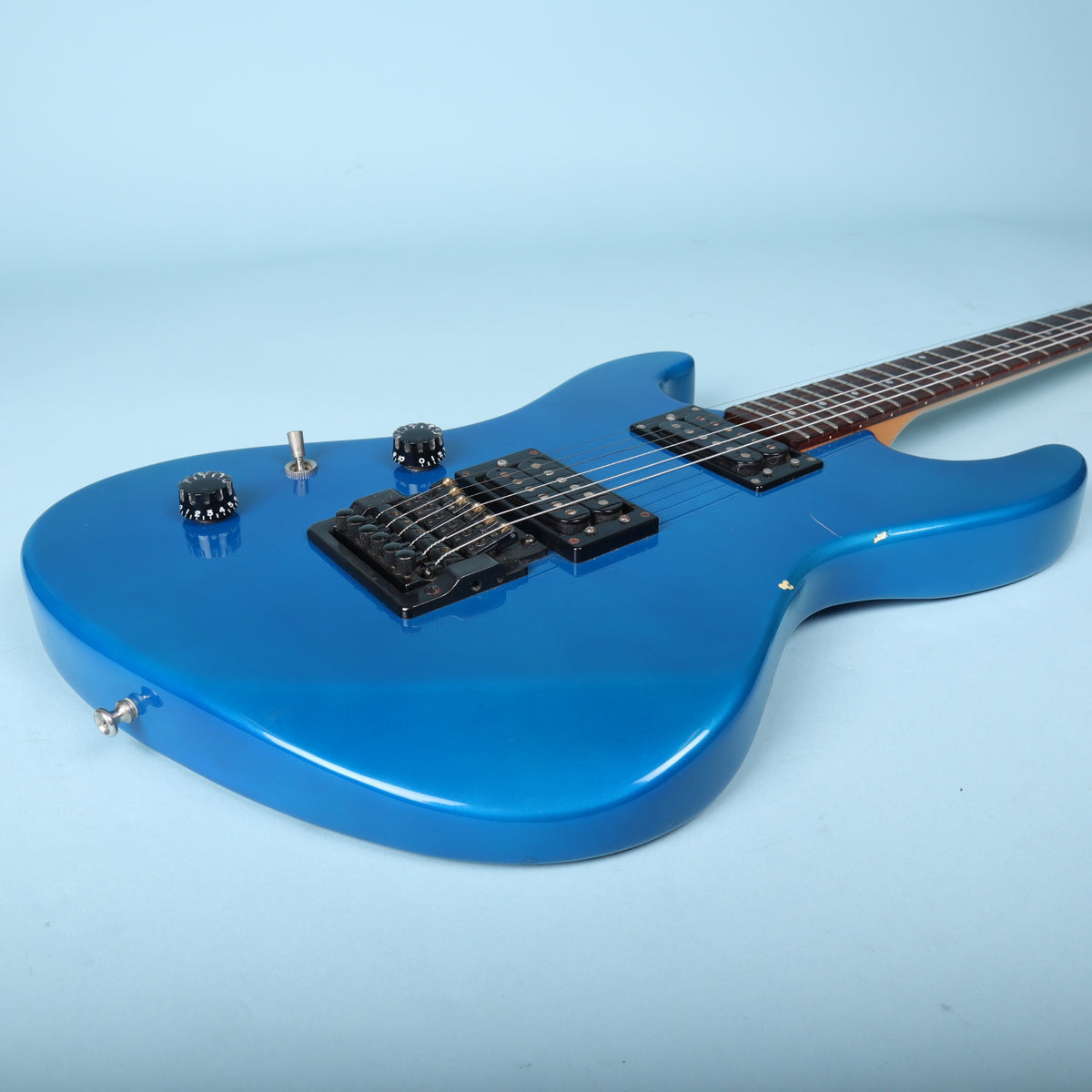Low-angle perspective across the metallic blue top and hardware