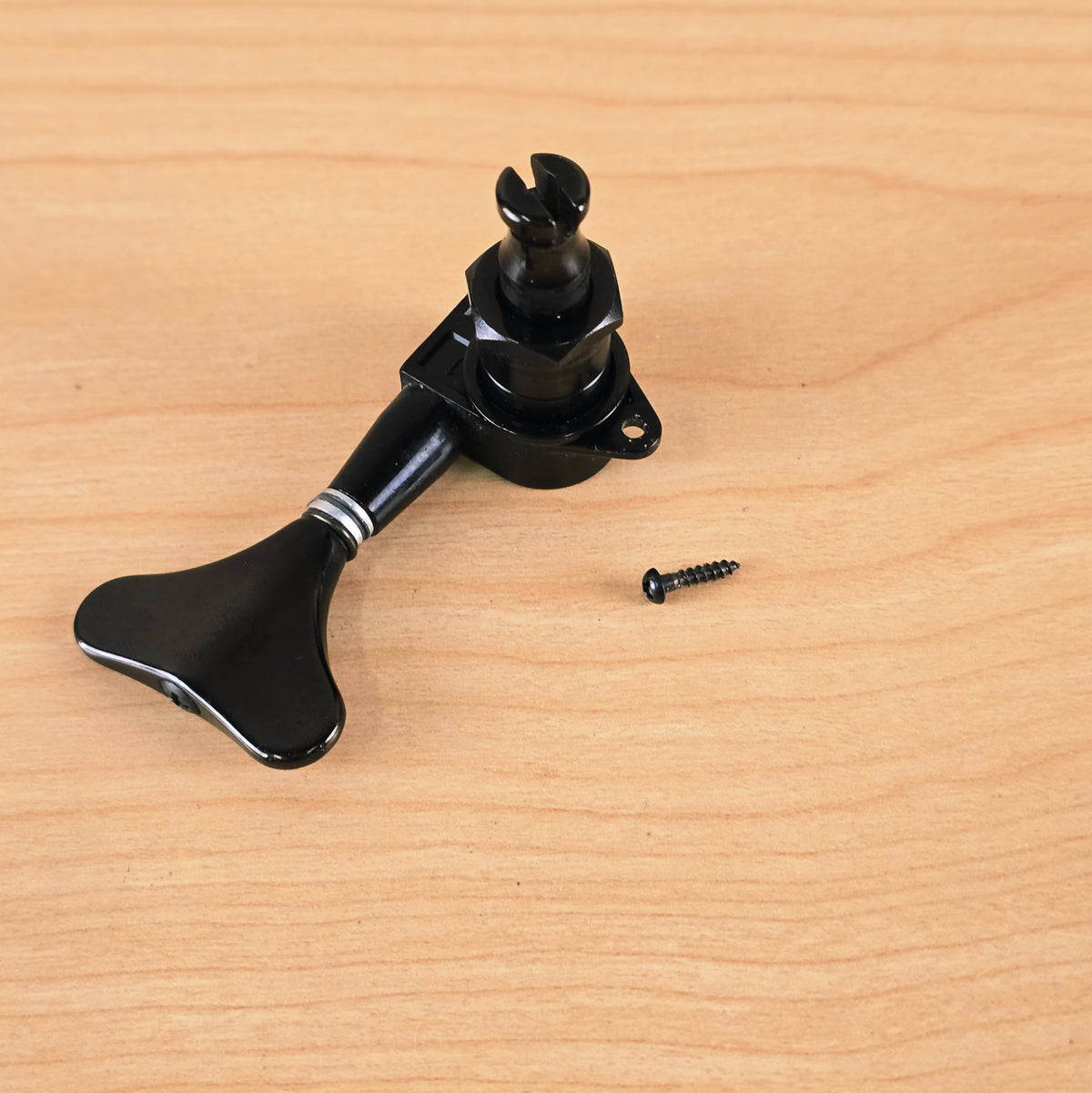 Angle view of the Gotoh bass tuning peg and mounting screw on wood