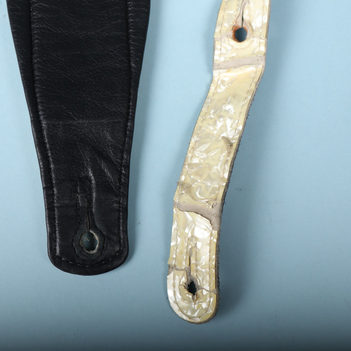 Front and back comparison showing the smooth black leather underside and the pearloid front strap end.