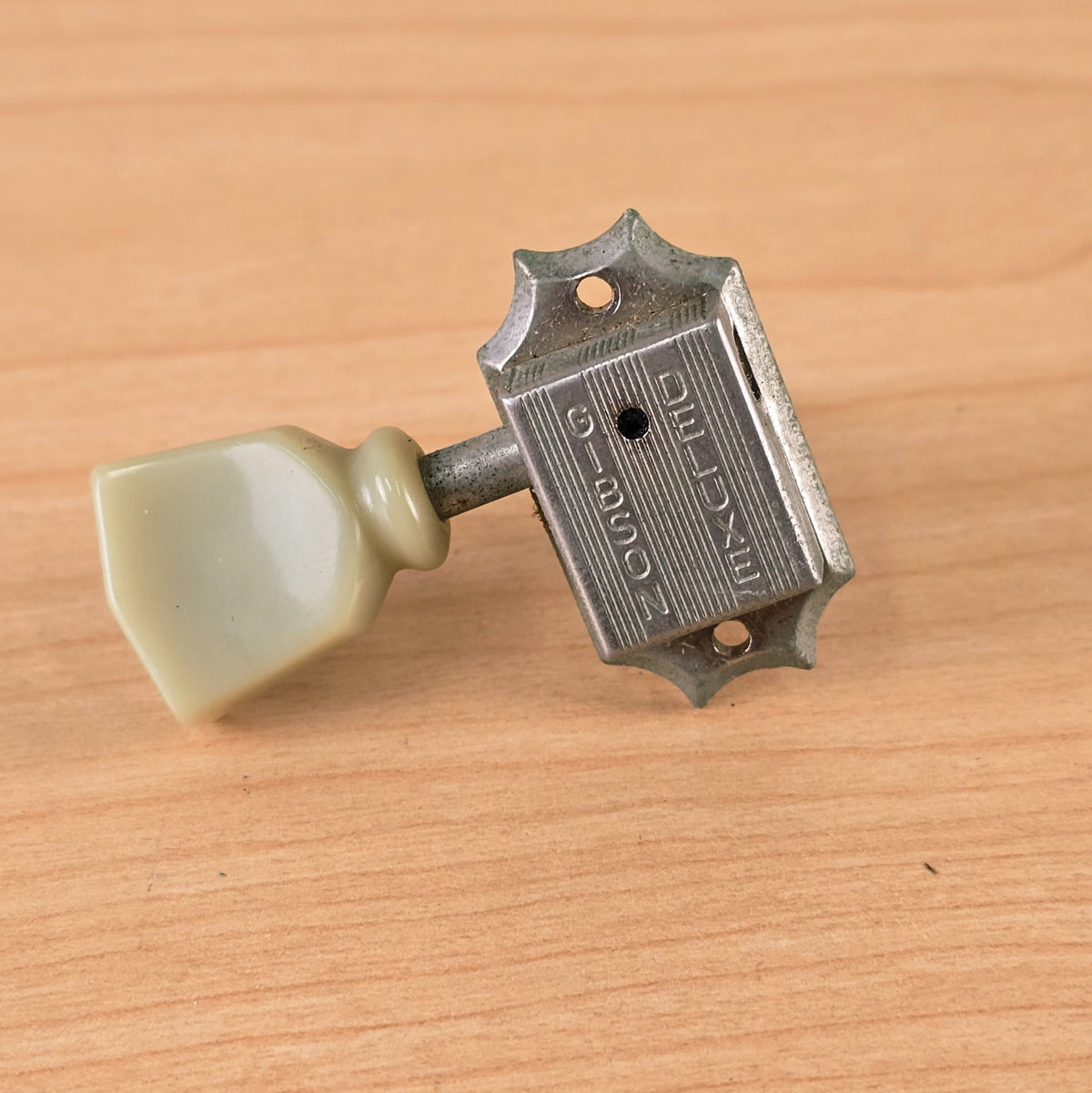 Top-down view of the Gibson Deluxe embossed casing and cream keystone button.