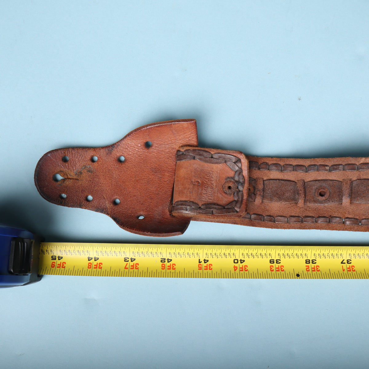 Tape measure showing vintage leather guitar strap length near 45 to 48 inches