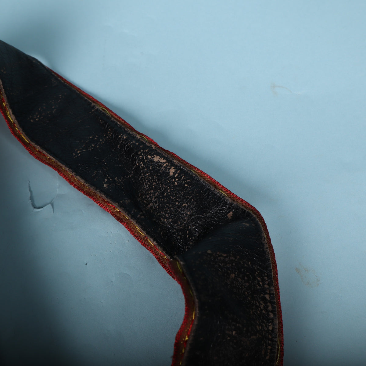 Close-up of worn black backing material on a Levy's guitar strap