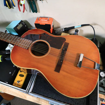 1967 Gibson B-25-12 vintage 12-string acoustic guitar on a workbench.