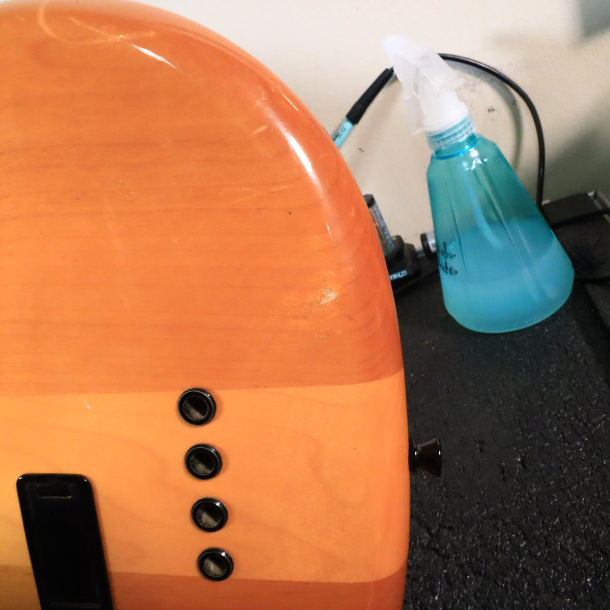 Close-up of the lower rear body edge showing a small finish nick near the string ferrules.
