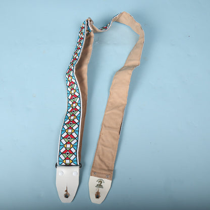 Authentic Hendrix guitar strap unfolded showing the length of the tan underside and jacquard face