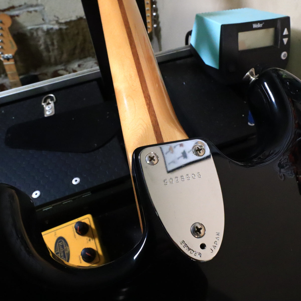 Close-up of chrome neck plate stamped with serial number SQ28506 and Fender Japan.