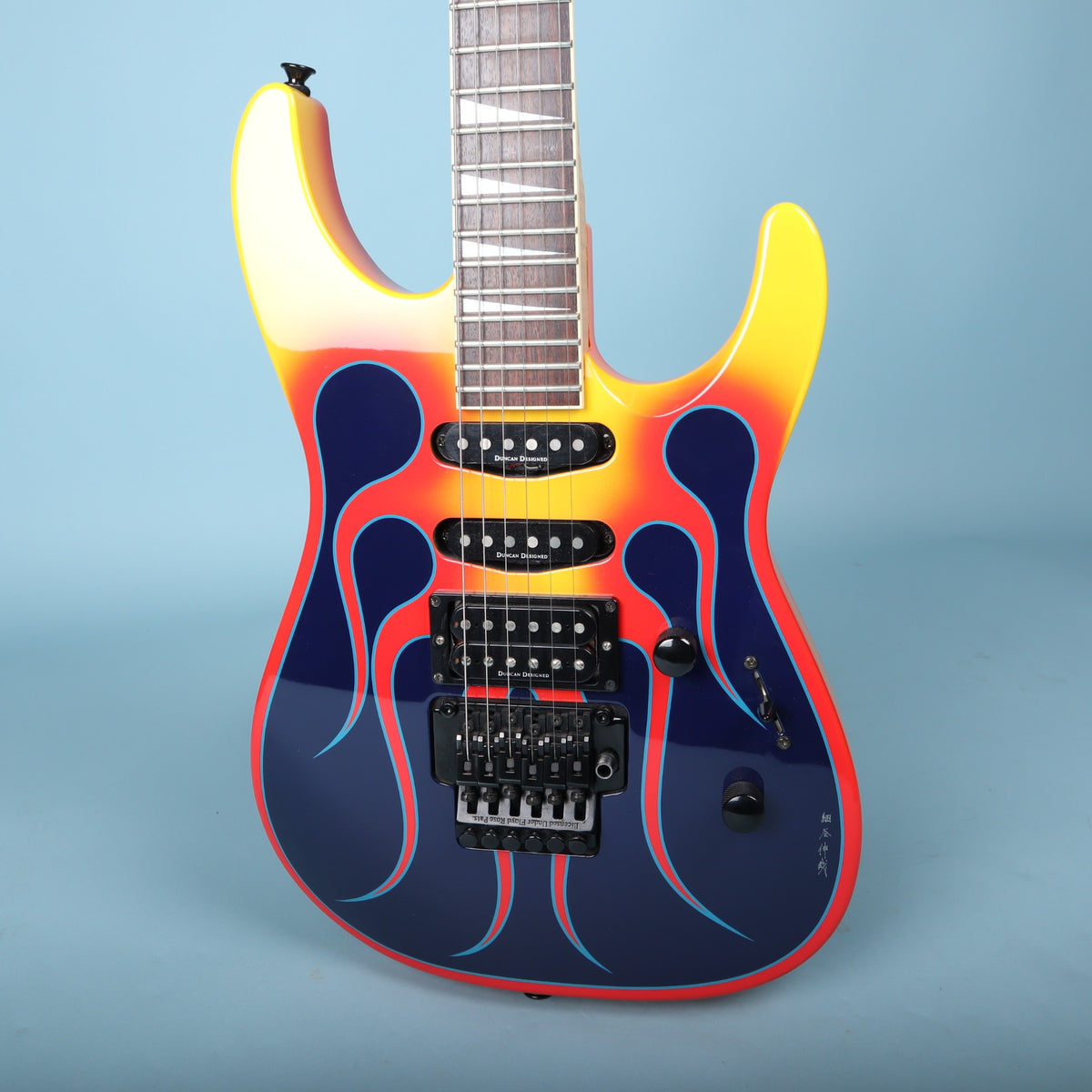 Front view of Jackson electric guitar with flame graphic finish and HSS pickup layout