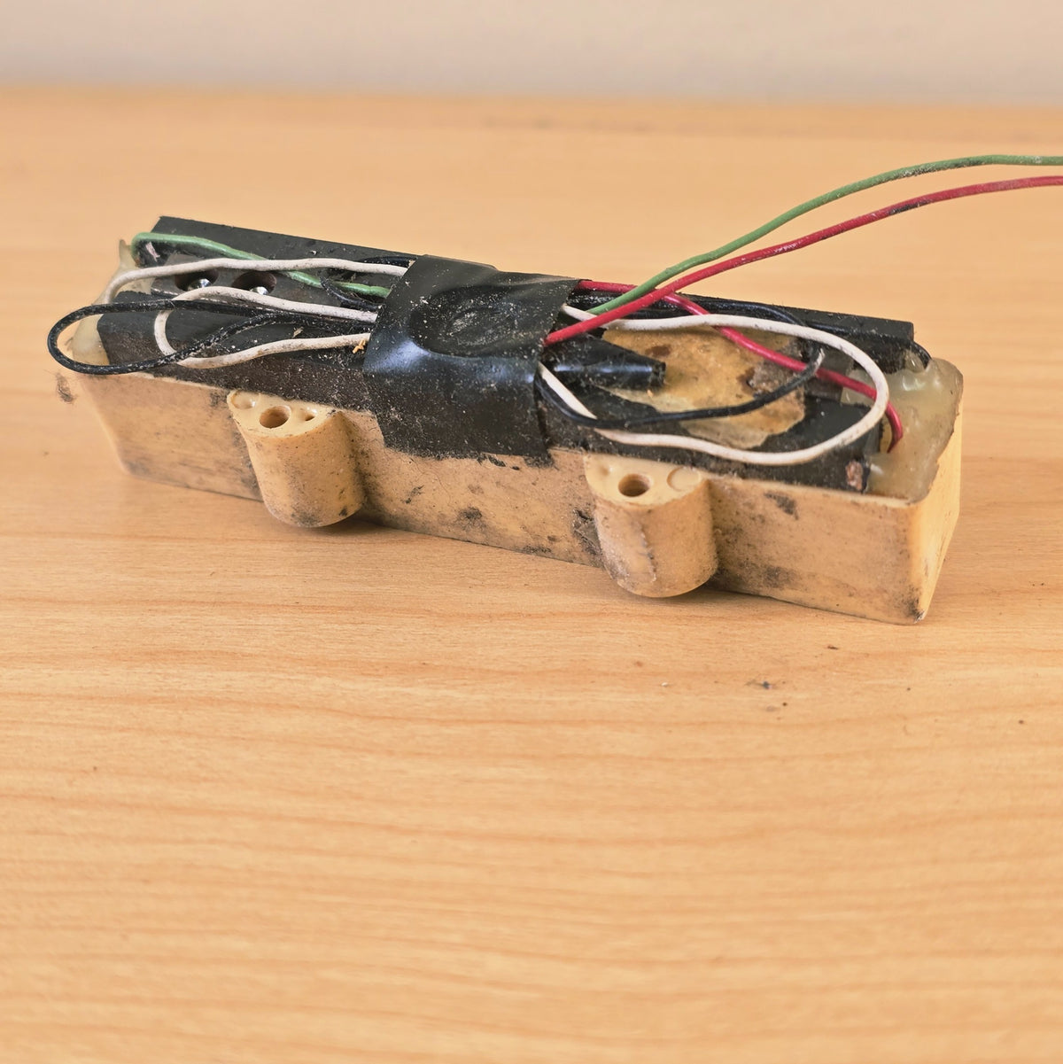 Detailed bottom view of wiring harness and potting on bass pickup.