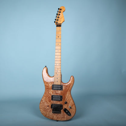 Full front view of 1980s Warmoth electric guitar against blue backdrop.