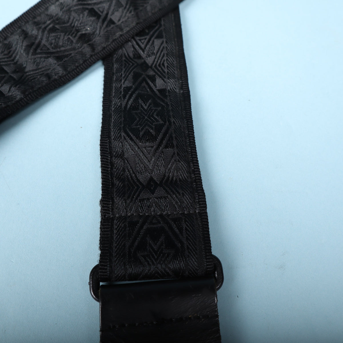 Close-up of the woven black geometric jacquard pattern and leather end attachment.