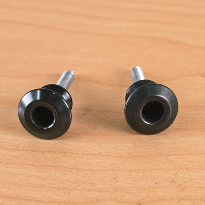 Direct front view looking into the flared recesses of two black Dunlop Straplok buttons