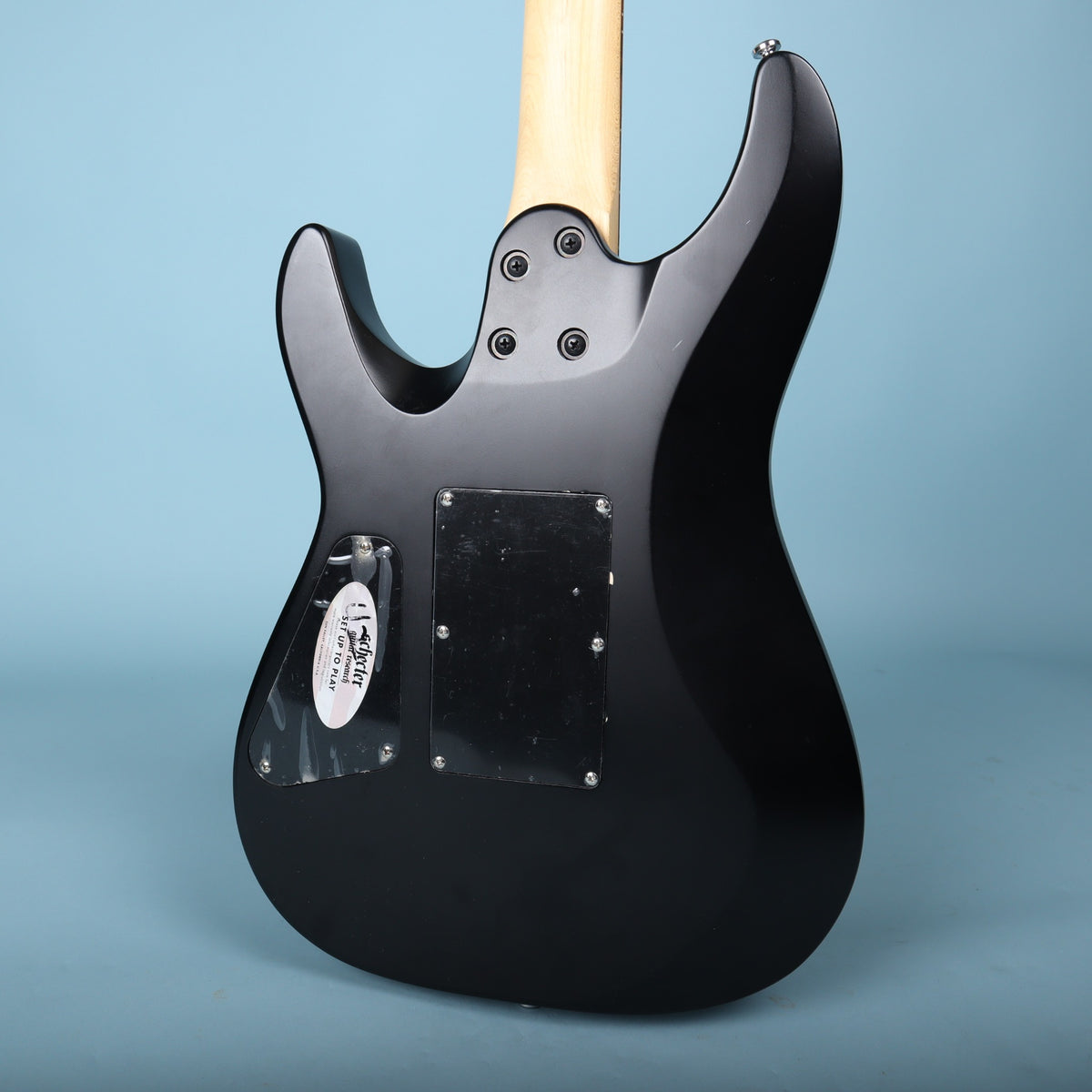 Rear view of the satin black guitar body showing the neck joint and cavity backplates.