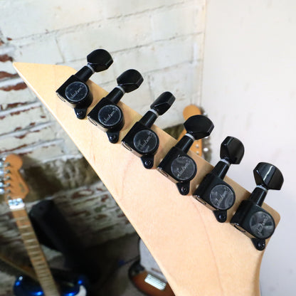 Close-up of black Jackson-branded tuning machines on rear headstock