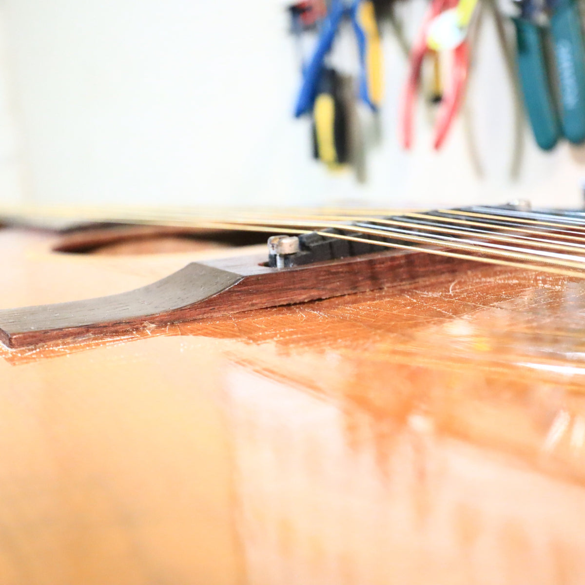 Low-angle view of the rosewood bridge saddle and strings on a Gibson B-25-12.