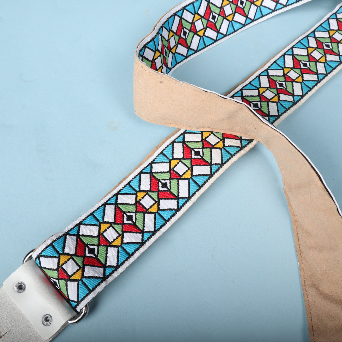 Detail of the multicolor geometric jacquard weave pattern crossing over the tan strap backing