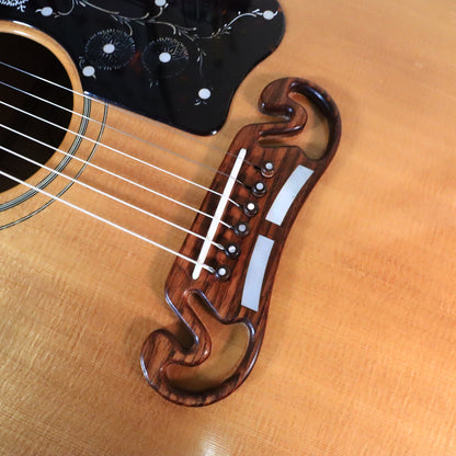 Close-up of rosewood mustache bridge with mother-of-pearl block inlays and bridge pins.