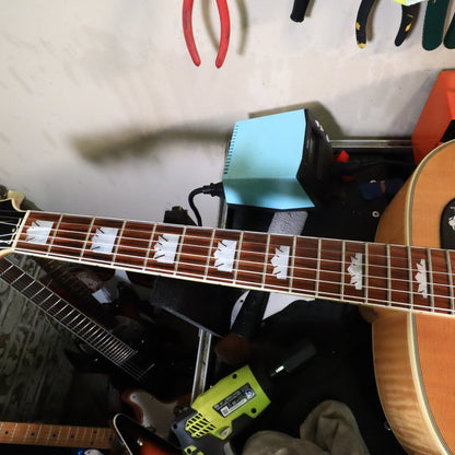 Close-up of frets and mother-of-pearl crown fingerboard inlays.