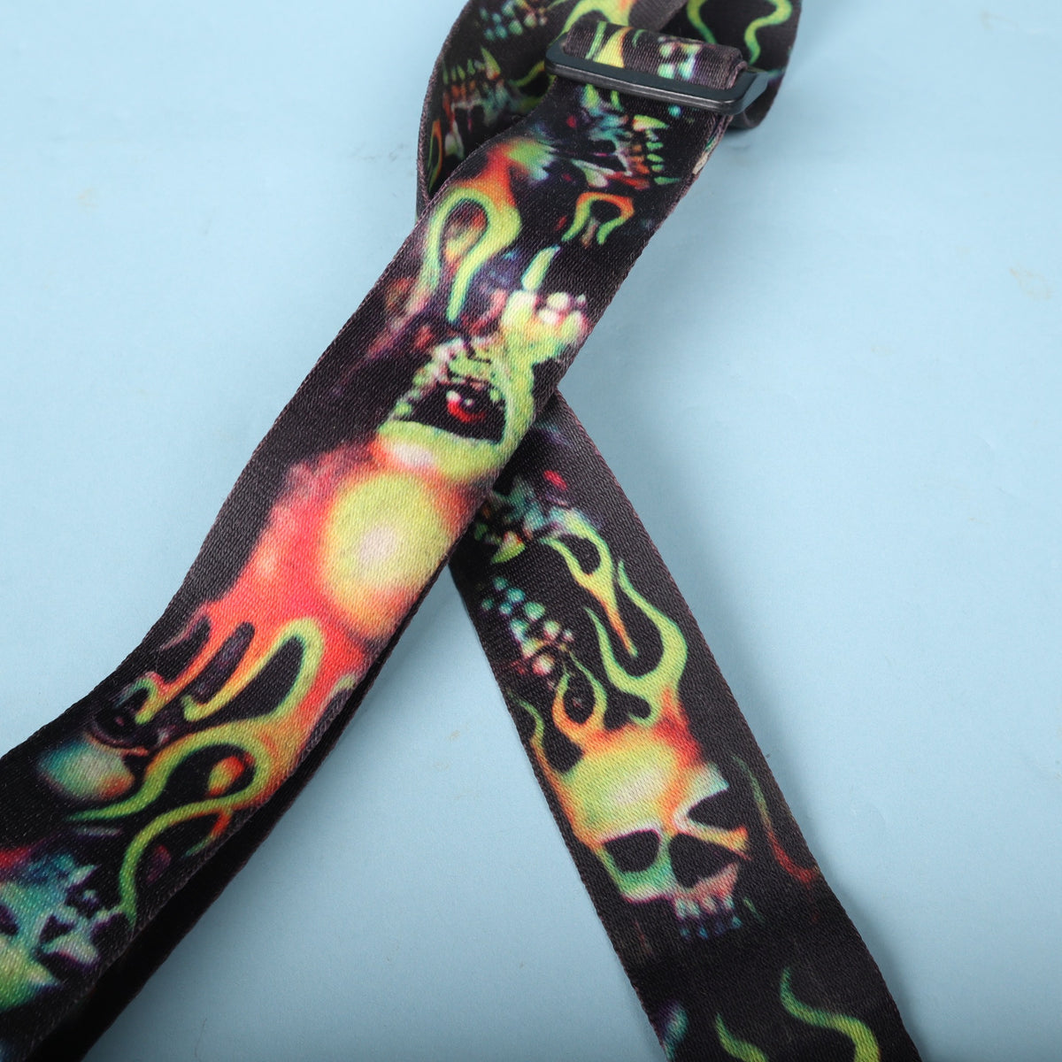 Close-up of the woven strap section displaying neon green and red flaming skull graphics.