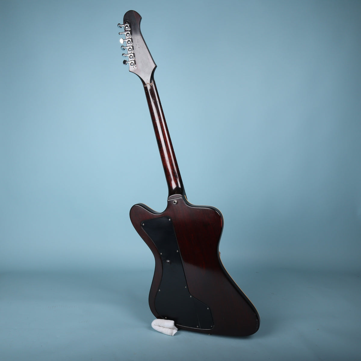 Full rear view of the guitar standing upright against a studio backdrop.