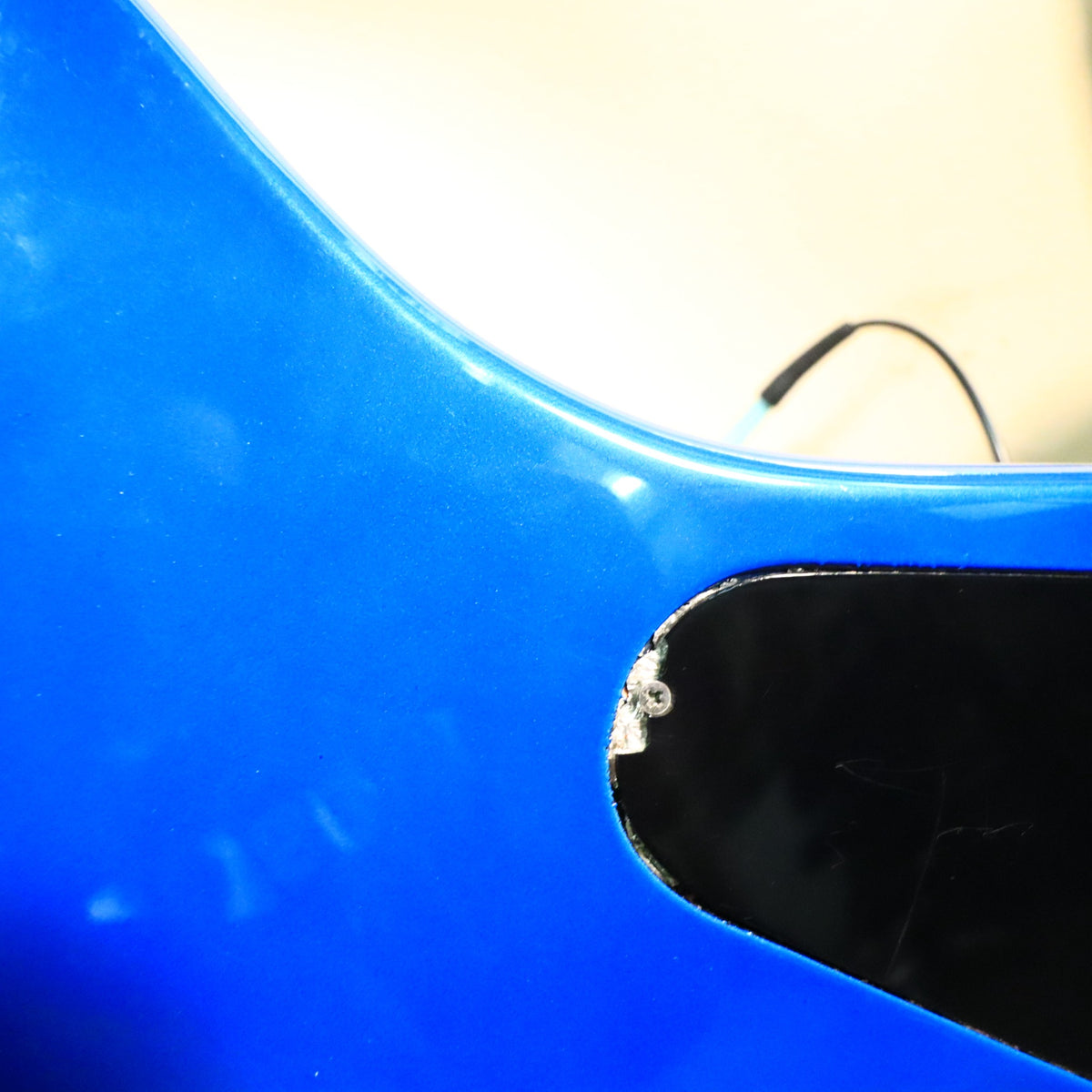 Close-up of a finish chip near the rear control plate screw