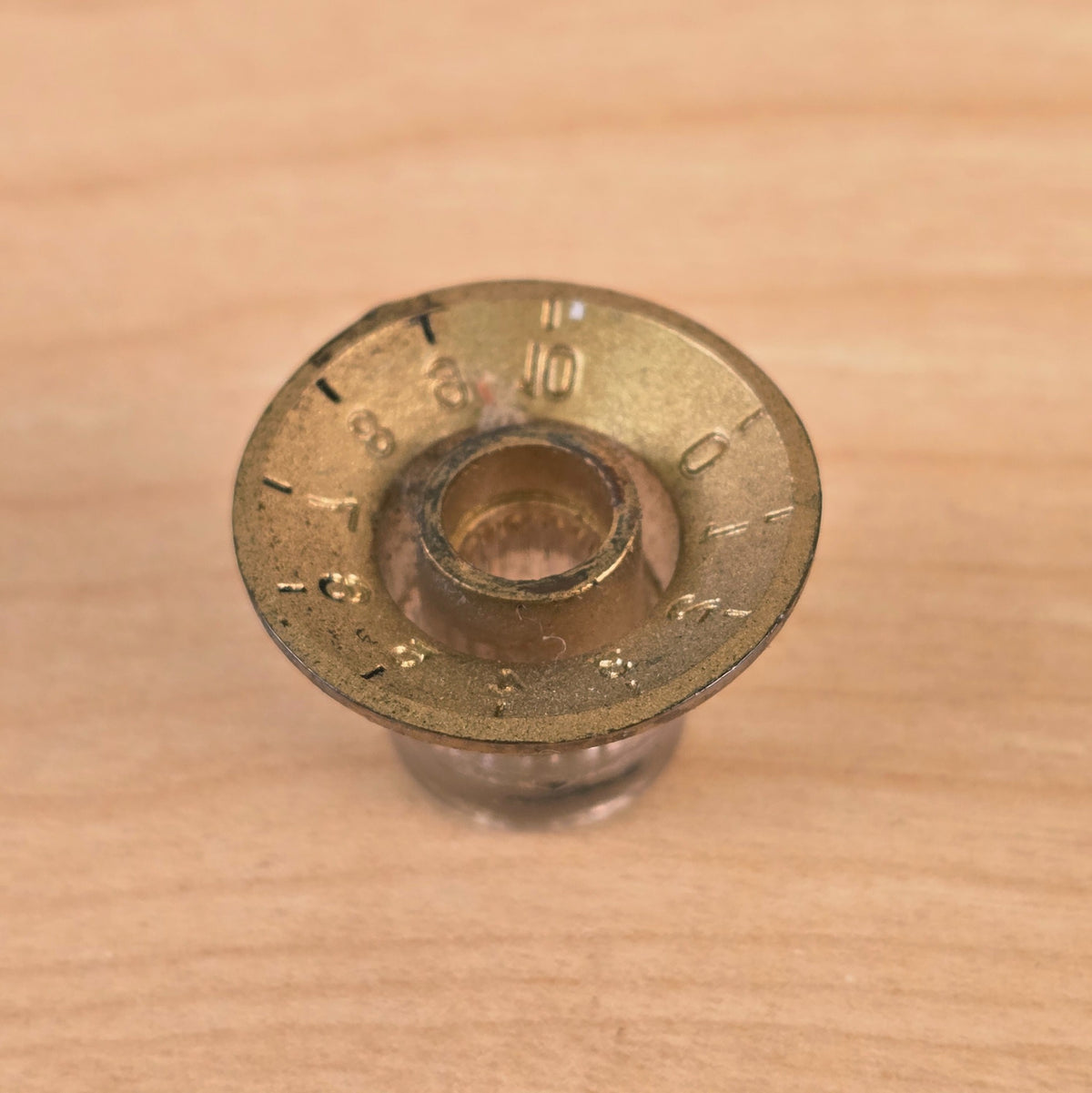Direct bottom view of gold top hat guitar control knob