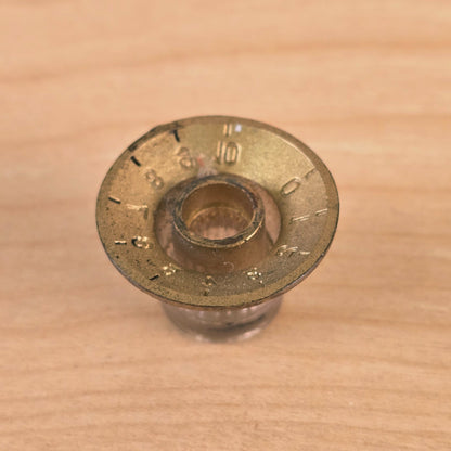 Direct bottom view of gold top hat guitar control knob