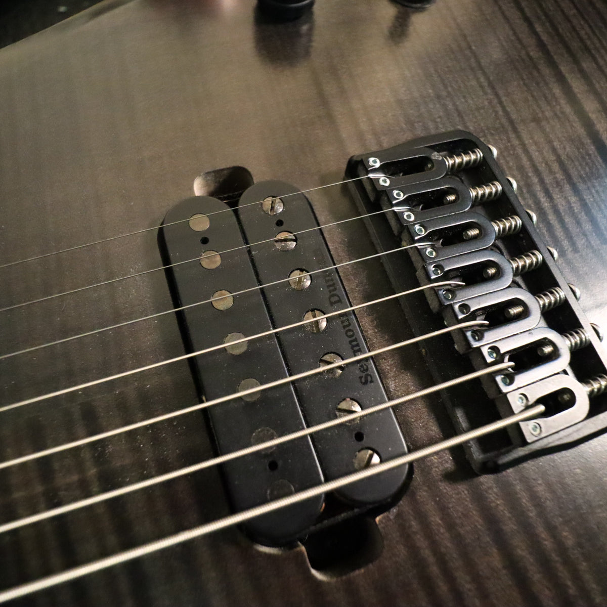 Front headstock angle on workbench showing string installation and truss rod access