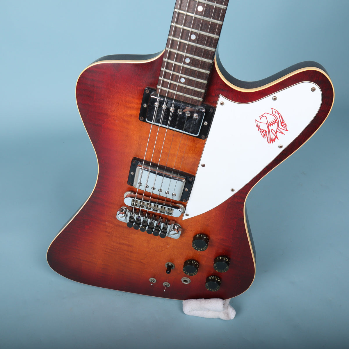 Front angled view of the Gibson Firebird II Artist body showing the sunburst flame maple top, pickups, bridge, and controls.