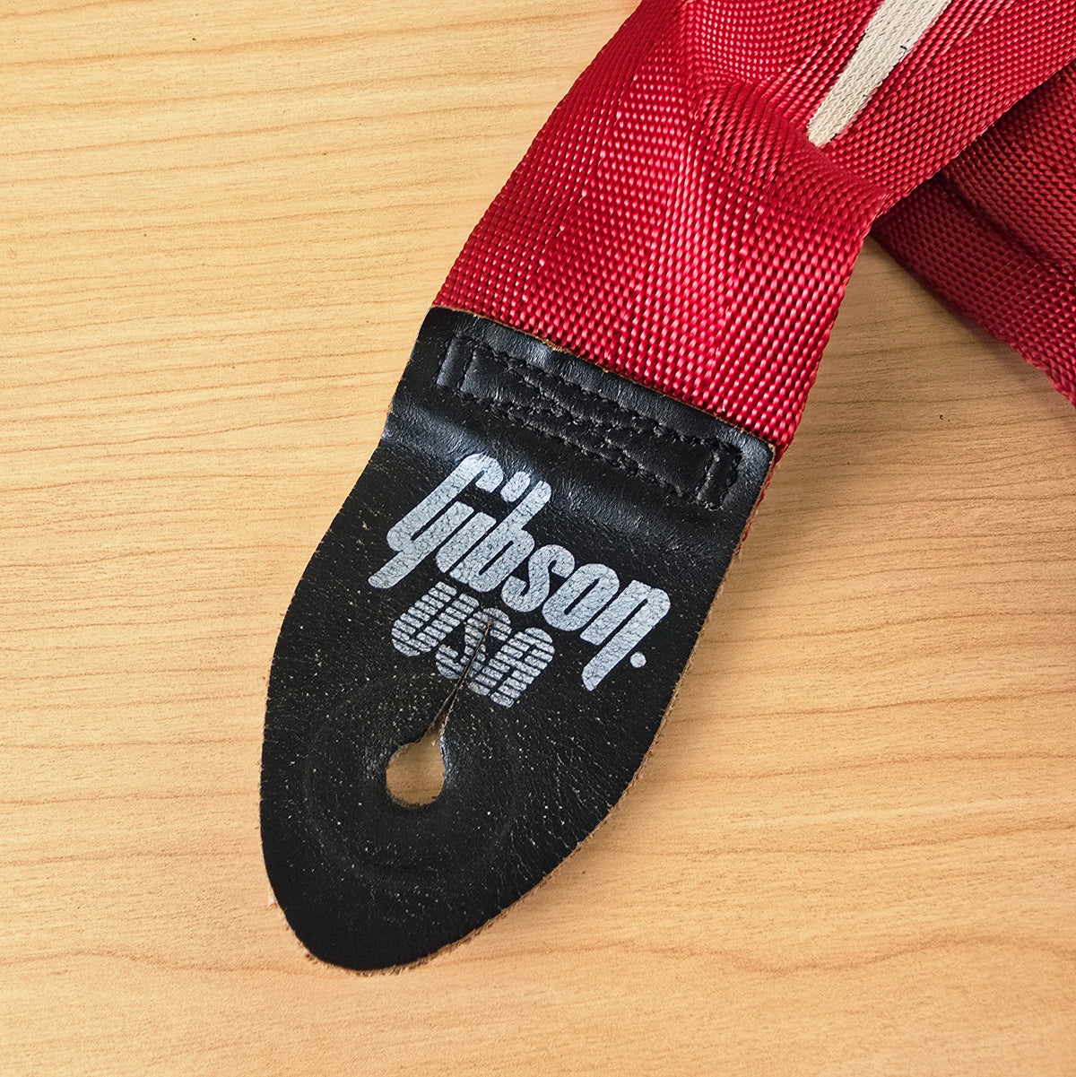 Close up of the Gibson USA logo printed on the black leather end tab