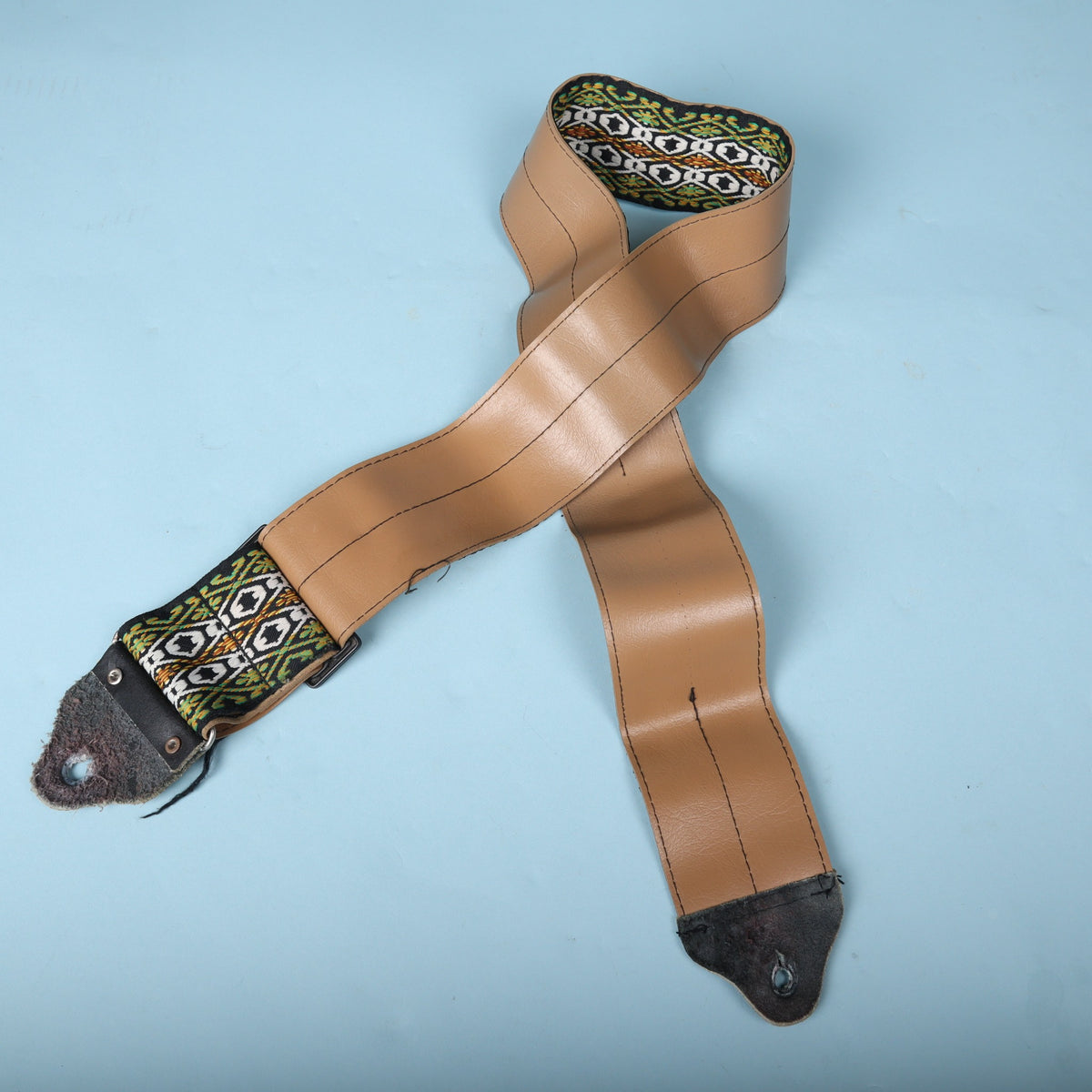 Rear overview of the vintage Ace bass strap displaying the wide tan vinyl backing and leather ends.