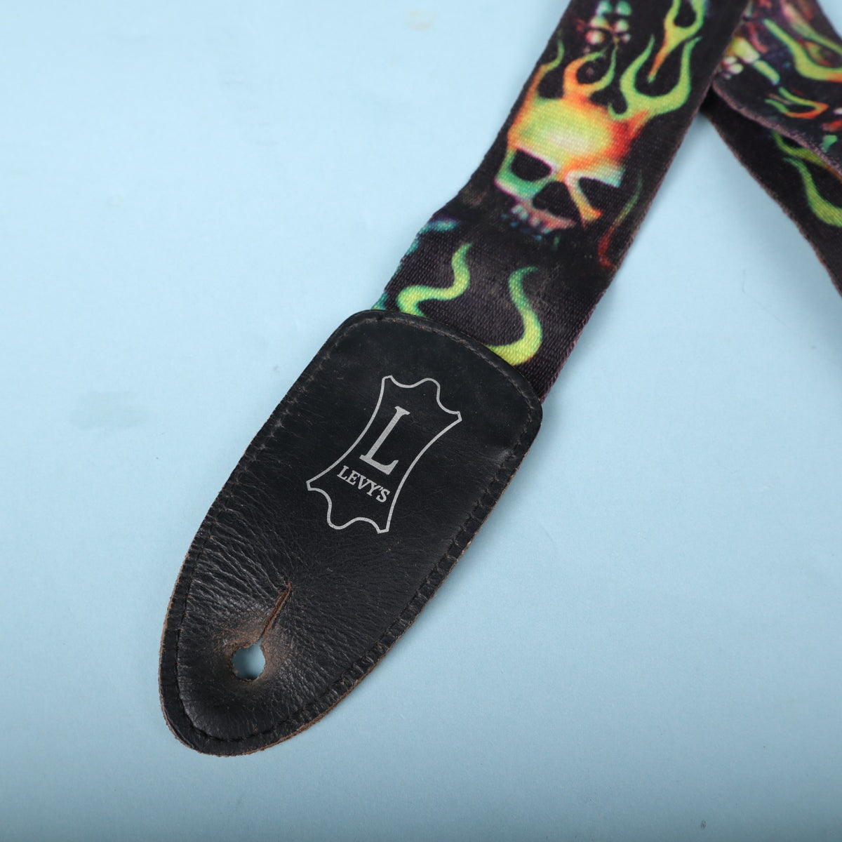 Front close-up of the embossed silver Levy's logo on the leather end piece.