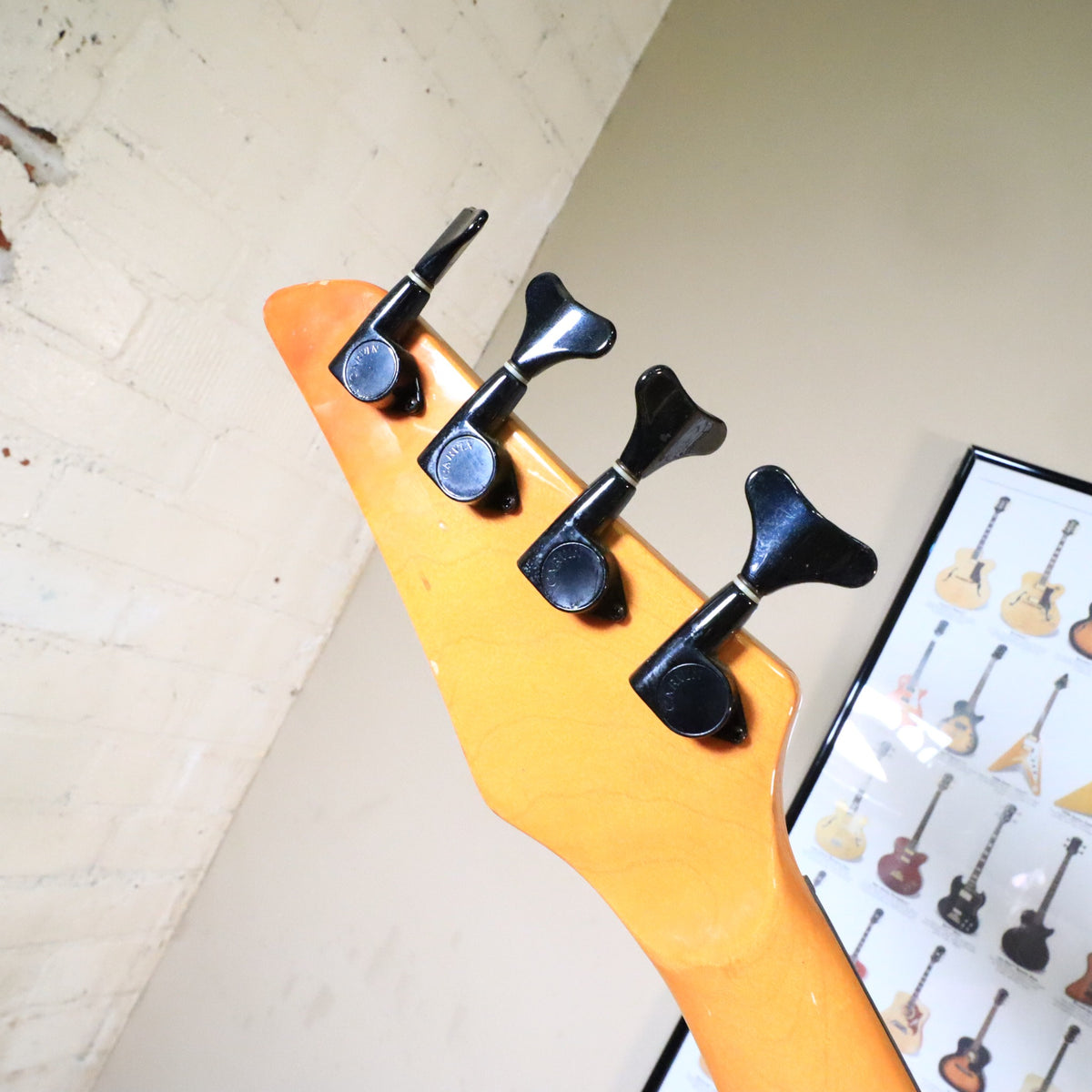 Angled view of the back of the headstock showing black tuning machines.