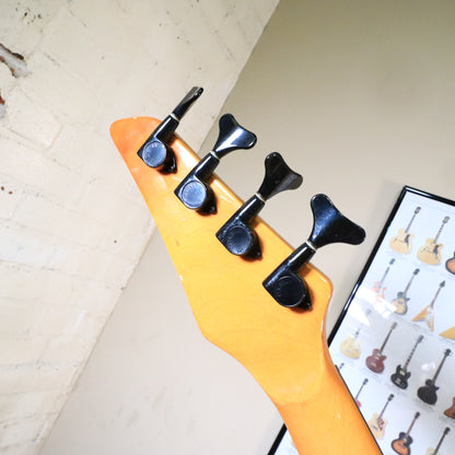 Angled view of the back of the headstock showing black tuning machines.