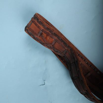 Detail of folded leather strap end showing hand-laced trim