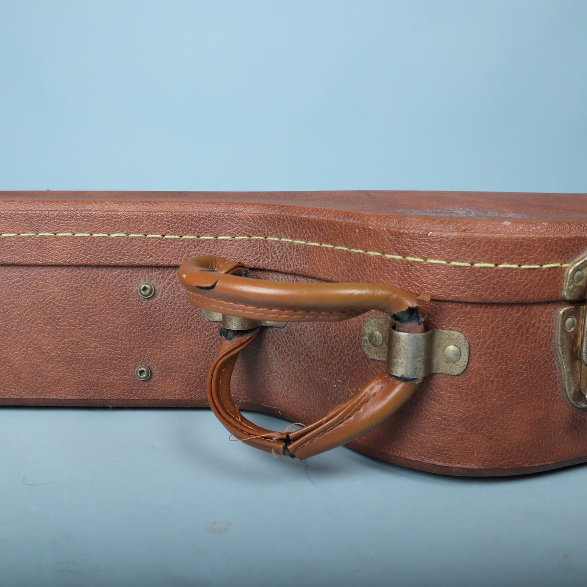 Detail of the brown padded handle showing some wear and split wrap
