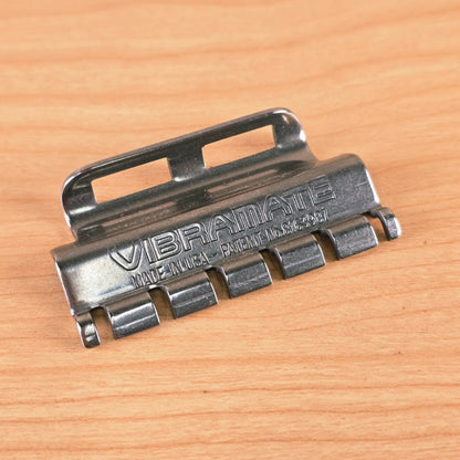Angled top-down view of the Vibramate Spoiler on a wooden surface highlighting the metal finish.