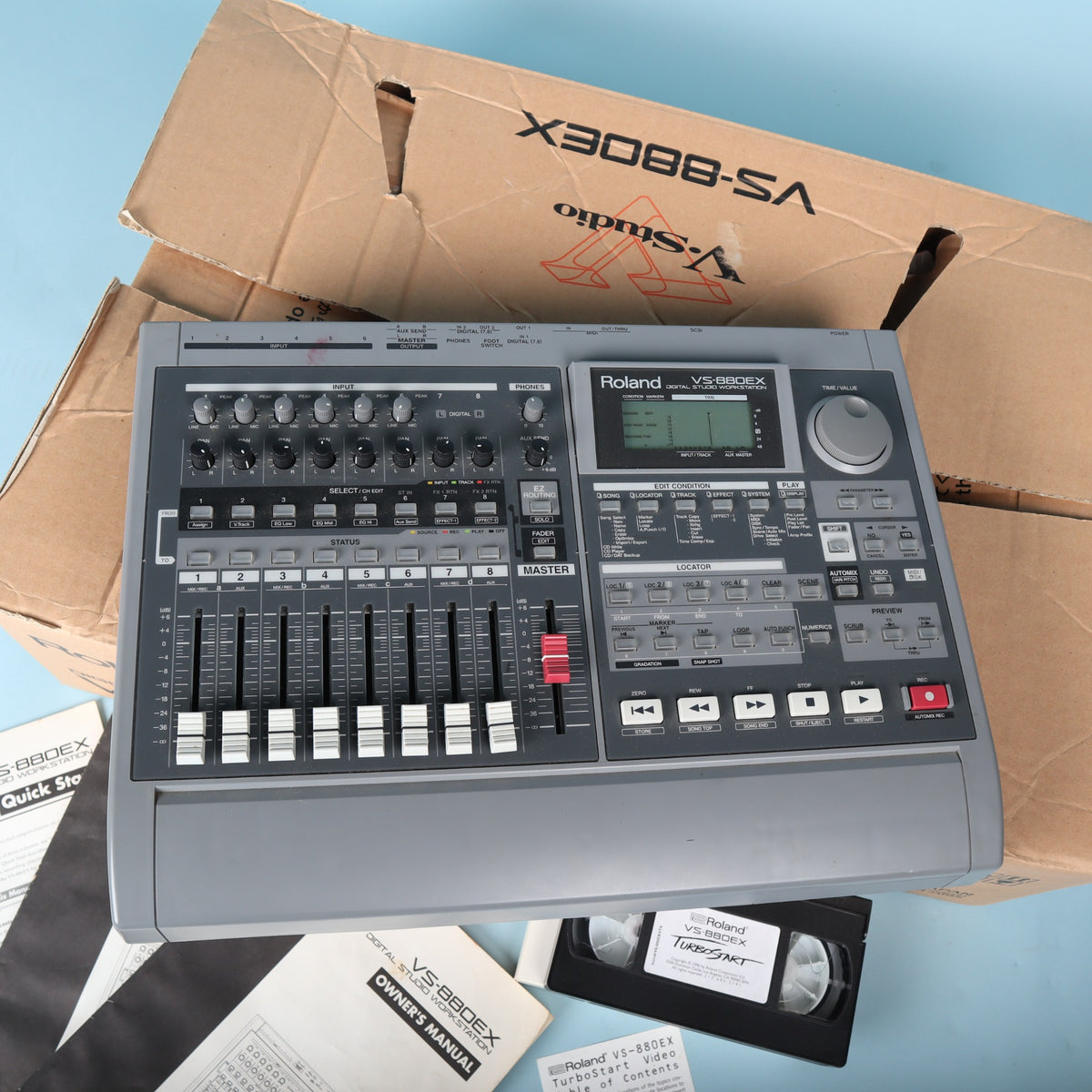 Top control surface of Roland VS-880EX showing faders, routing controls, display, and jog wheel.
