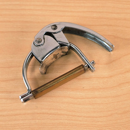 Overhead view of the closed Hamilton KB19A Fast Action guitar capo on a light wood surface.