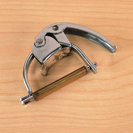 Overhead view of the closed Hamilton KB19A Fast Action guitar capo on a light wood surface.