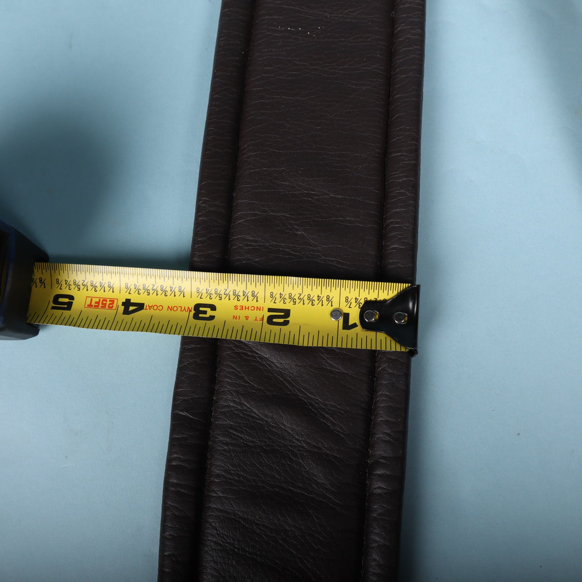 Tape measure showing 3-inch width across the padded body of the strap