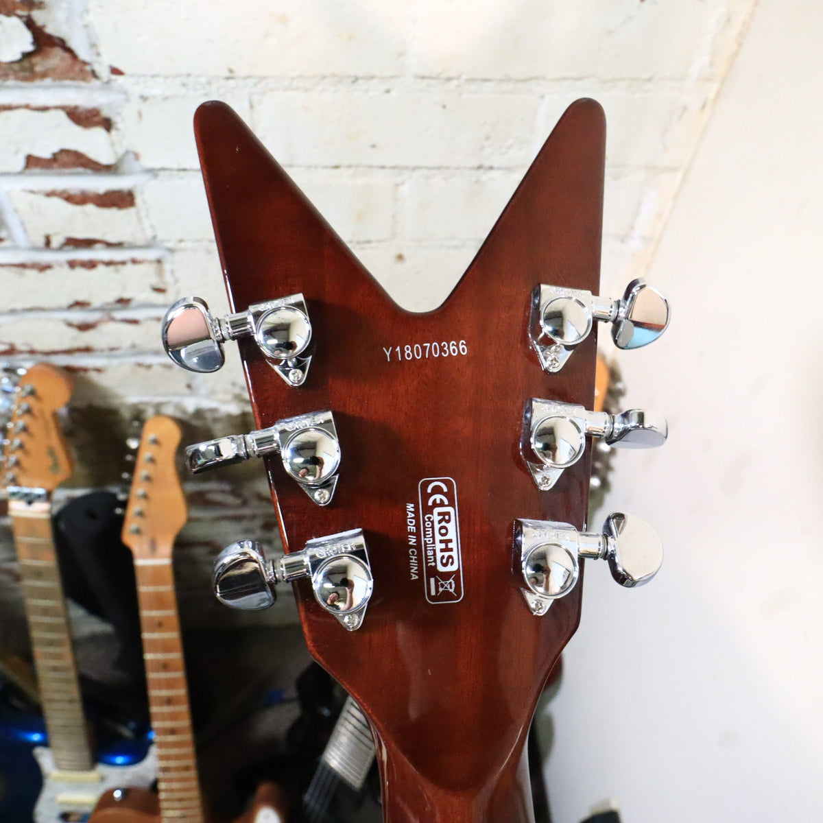Close view of back of Dean ML headstock showing Grover tuning machines on workbench