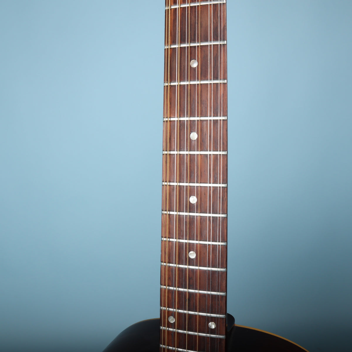Close-up of the rosewood fretboard with dot inlays and clean frets.