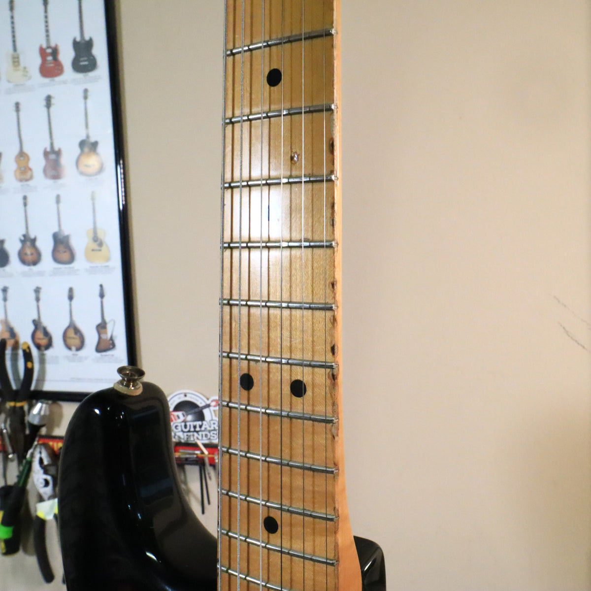 Fretboard view alongside a reference poster in a workshop setting